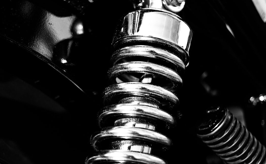 Gros plan en noir et blanc sur un ressort de suspension moto